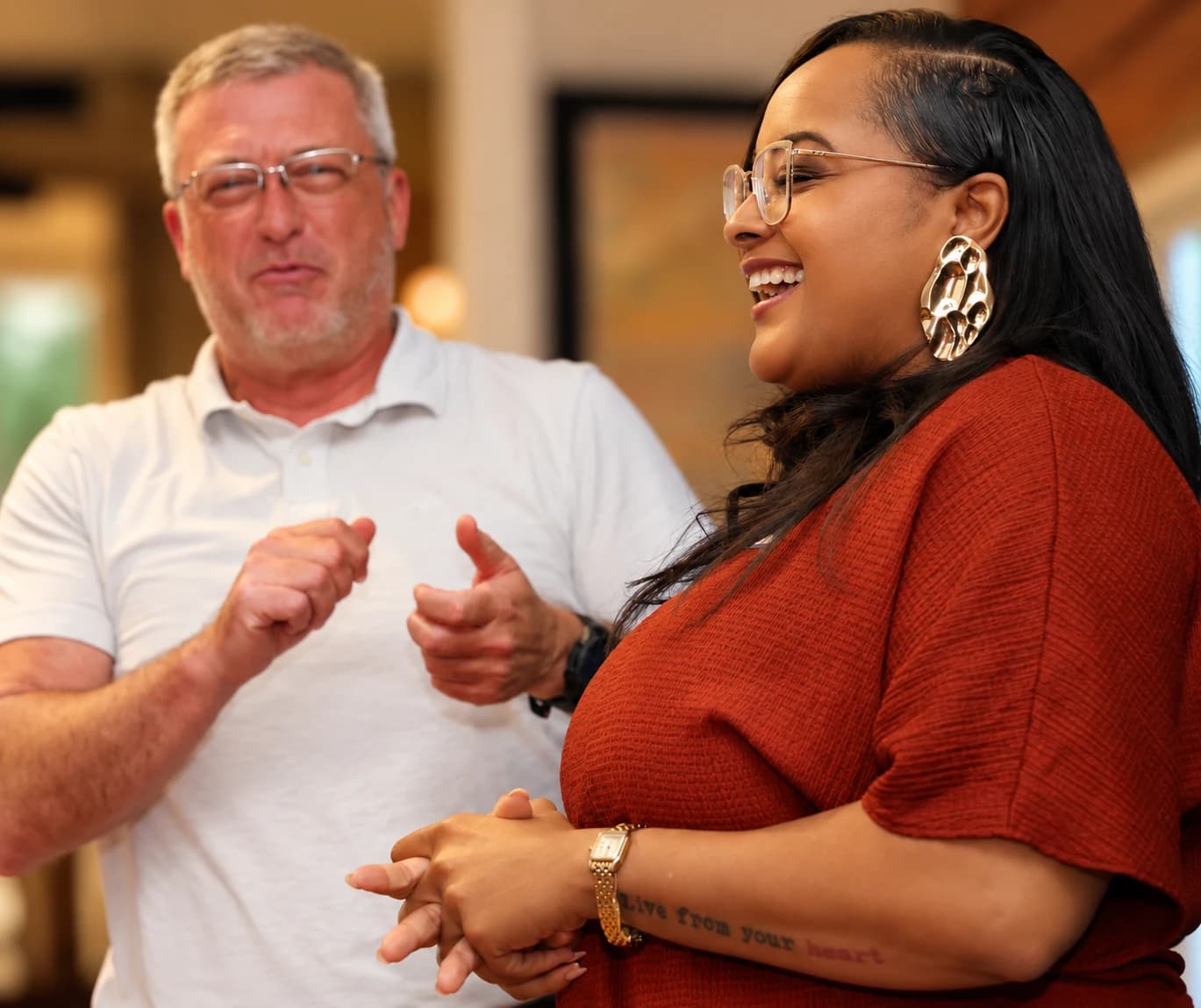 A man and a woman laughing mid-conversation at a speed dating evening